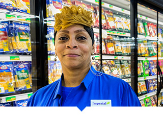 Imperial Fresh Market employee in Detroit poses in aisle of grocery store